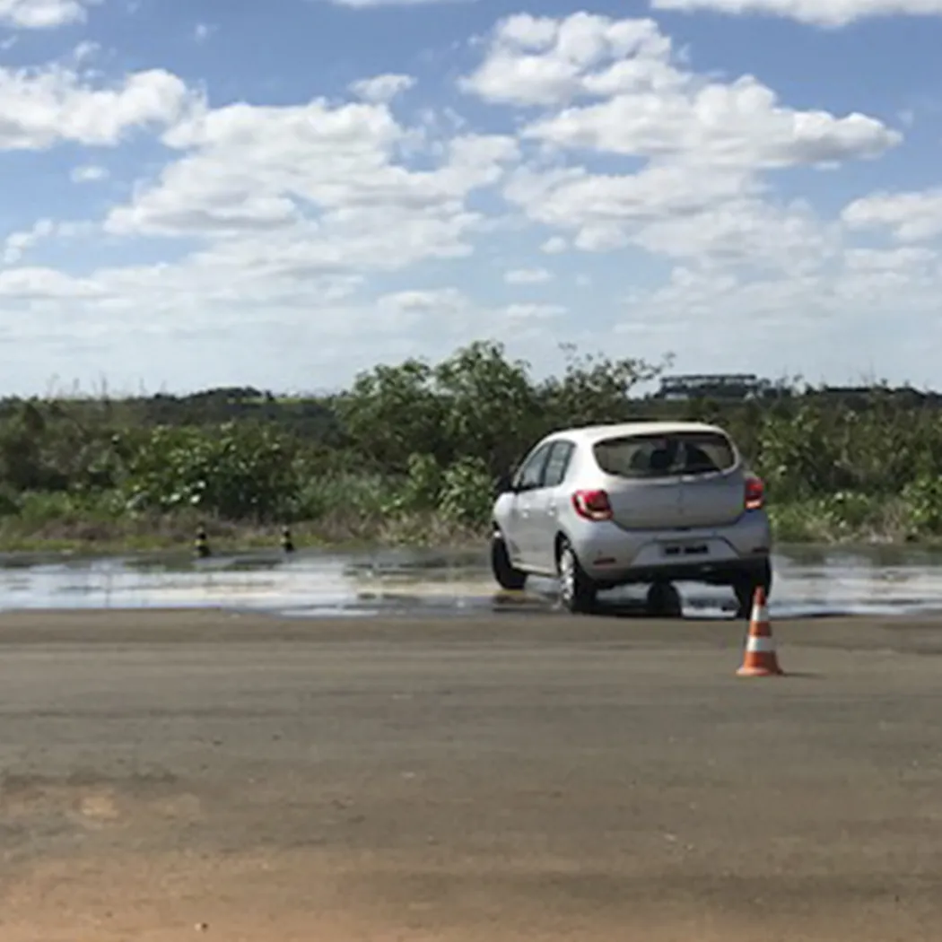 Veículo em exercício de baixo atrito sobre piso molhado