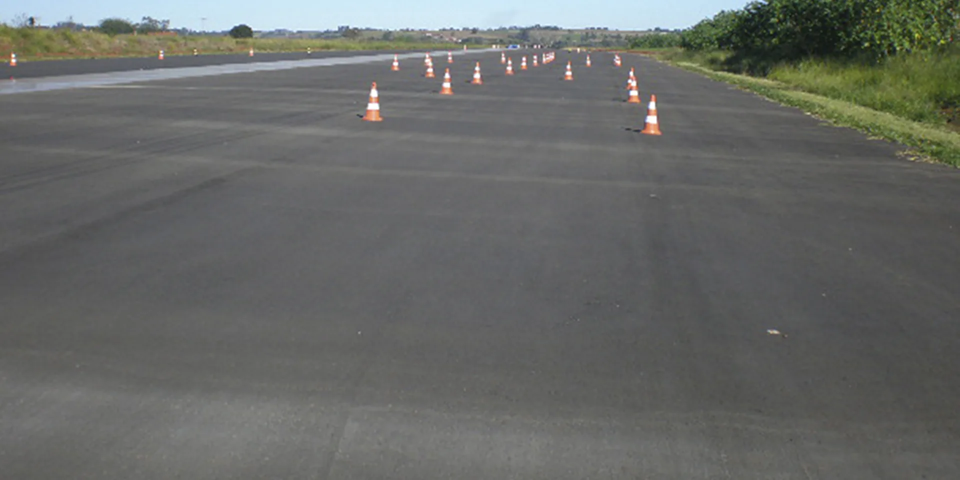 Reta de treinamento demarcada com cones laranja, em preto e branco