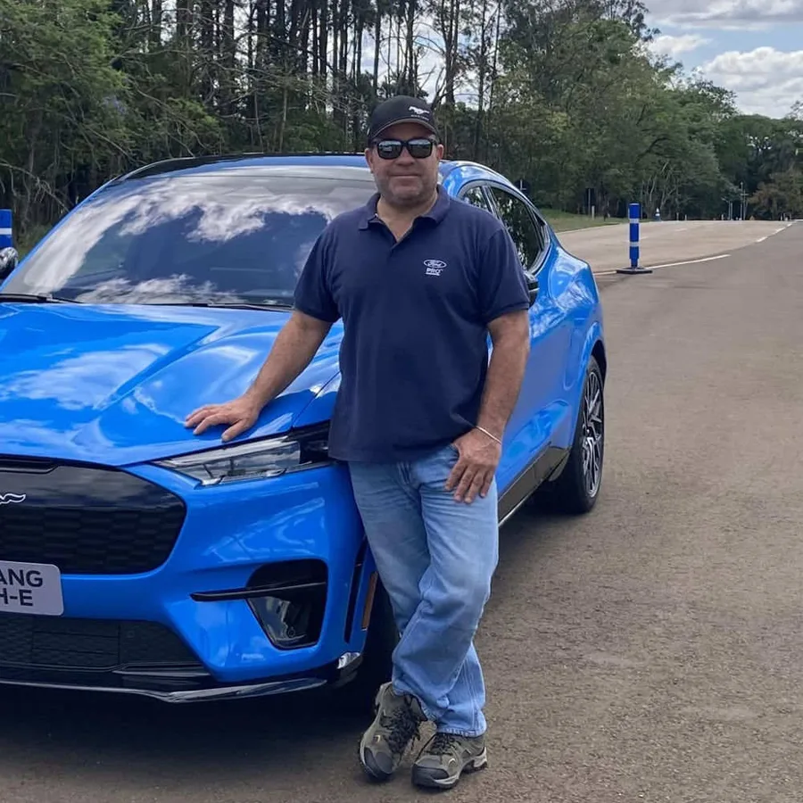 Marcelo Oliveira, instrutor responsável da T3 Driver, ao lado de um Mustang Mach-E em pista de testes